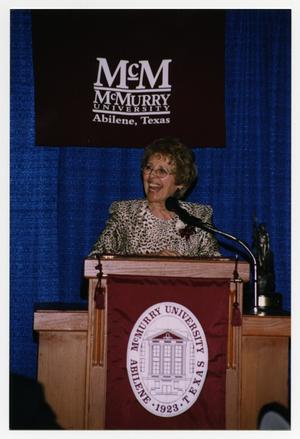 [Photograph of Mary Esther Paquet Bynum at Podium]