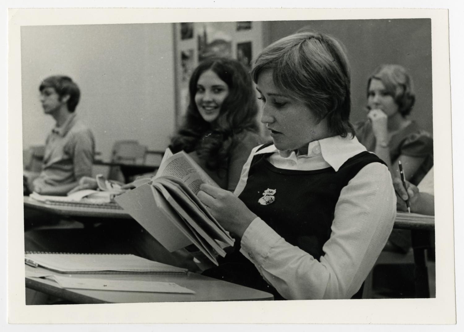 [Photograph of Debby Baker Reading a Book in Class]
                                                
                                                    [Sequence #]: 1 of 2
                                                