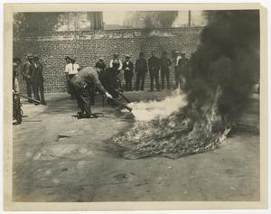 Primary view of object titled '[Photograph of Men Putting Out Fire]'.