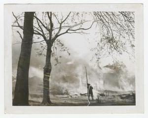 [Photograph of Firefighter by Burning Building]