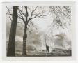 Photograph: [Photograph of Firefighter by Burning Building]