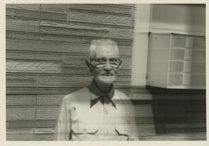 [Photograph of Older Man in Front of Faux Stone]