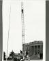 Primary view of [Photograph of Fire Truck with a Man on its Ladder]