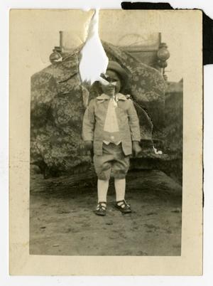 [Young Boy Standing in front of Covered Car]