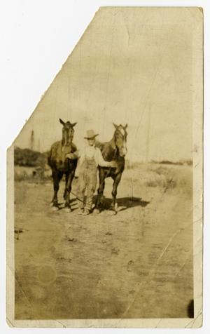 Primary view of object titled '[George Pruitt Leading Two Horses]'.