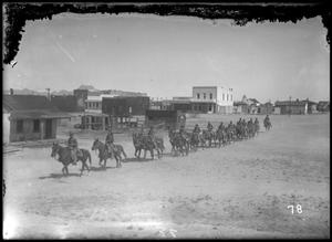 Primary view of object titled '[Mounted U.S. Army Soldiers Riding Through a Town]'.