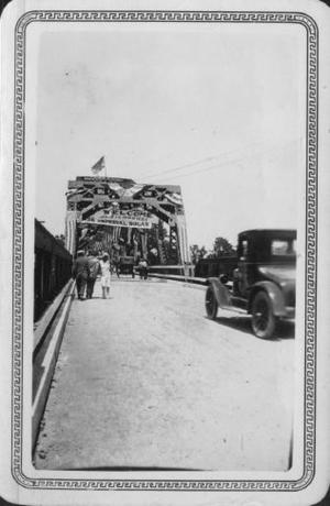 [People and automobiles crossing during opening ceremonies of the Brazos River Bridge]