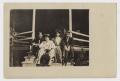 Postcard: [Four Men and Women Sitting on the Front Steps of a Building]