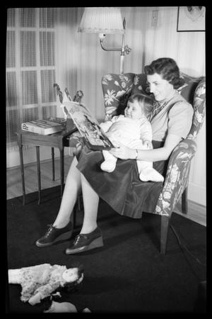 Young Woman Seated in Chair Reading to Child