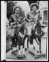 Thumbnail image of item number 1 in: 'Two Men Wearing Sombreros Riding Toy Horses'.