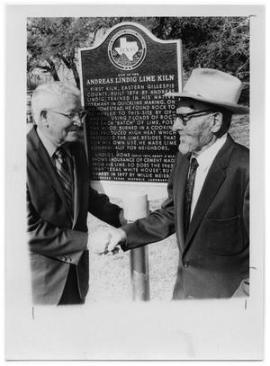 [Otto Lindig Shaking Hands with a Man under a Historical Marker