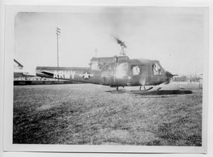 Primary view of object titled '[Army Helicopter on a Field]'.