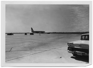 Primary view of object titled '[Airplane on a Runway with Several Nearby Vehicles]'.