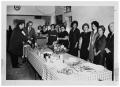 Photograph: [People Standing at a Table Laden with Food]