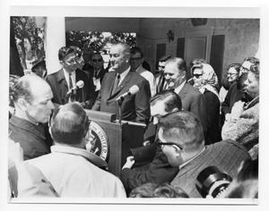 Primary view of object titled '[Lyndon Johnson Surrounded at a Podium]'.