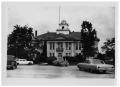 Photograph: [Two Story Building with Cars Parked in Front]