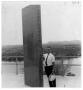 Photograph: [Man Stands Next to a Sign for Lake Lyndon B. Johnson]