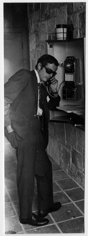 [Man Wearing Sunglasses and Using a Payphone]