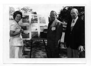 Primary view of object titled '[Lady Bird Johnson Stands Near a Poster]'.