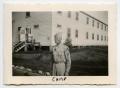 Photograph: [Photograph of a Soldier near a Cabin]