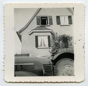[Photograph of a House Taken in Front of a Vehicle's Hood]