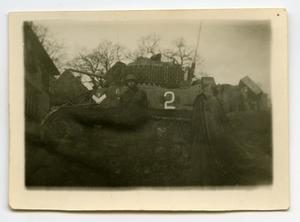 [A Soldier Standing Against the Side of a Tank]