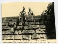 Primary view of [John Muth and a Fellow Soldier Sitting on a Wall]