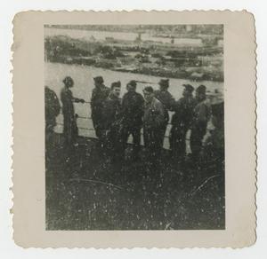 [A Group of Soldiers Standing on the Rail of a Ship]