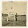Photograph: [Photograph of Soldier Standing Beside U.S. Occupation Sign]