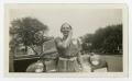 Photograph: [Photograph of a Woman in front of a Car]
