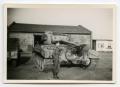 Photograph: [A Soldier Standing Against a Large Tank]