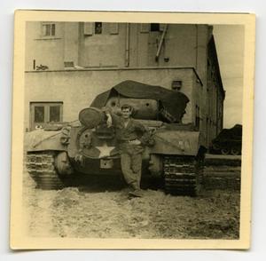 [A Soldier Standing in Front of a Covered Tank]