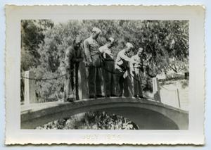 [A Group of Soldiers Stands Over a Small Bridge]