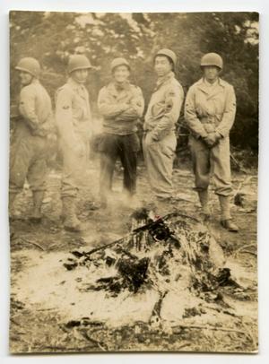 [A Group of Soldiers Standing Next to a Campfire]