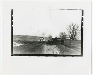 Primary view of object titled '[An Armored Vehicle Passing a Burning Vehicle]'.