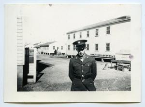 [Photograph of a Soldier near a Cabin]