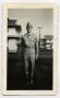 Photograph: [Photograph of a Soldier in front of Barracks Buildings]