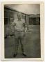 Photograph: [Photograph of Harold Wells in Front of Hut]
