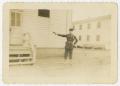 Photograph: [Man Shooting Pistol In Front of Building]