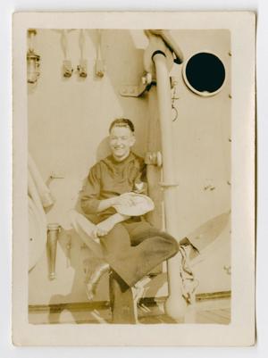 [Photograph of a Sailor Sitting on an Anchor]