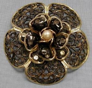 [Black lace floral pin with gold trim and pearl in center]