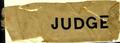 Physical Object: [Beige silk ribbon that states: "JUDGE"]