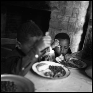 [Two Children Eating at a Table]