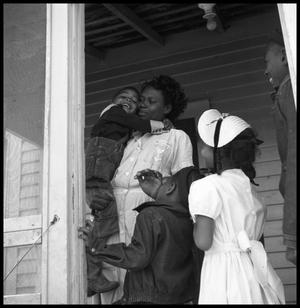 [Woman Standing in a Porch Doorway with Children]
