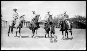 [Four Cowboys on Horseback behind a Boy]