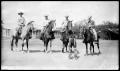Photograph: [Four Cowboys on Horseback behind a Boy]
