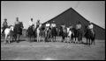 Photograph: [Ten Horses with Riders by a Barn]