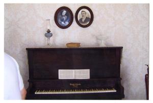 [Photograph of a Piano and Portraits in the Pound House]