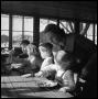 Photograph: [Woman Leaning Over an Eating Child]