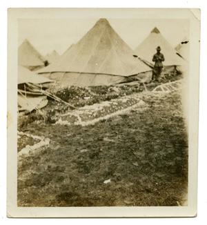 Primary view of object titled '[Photograph of Soldier Standing by Tents]'.